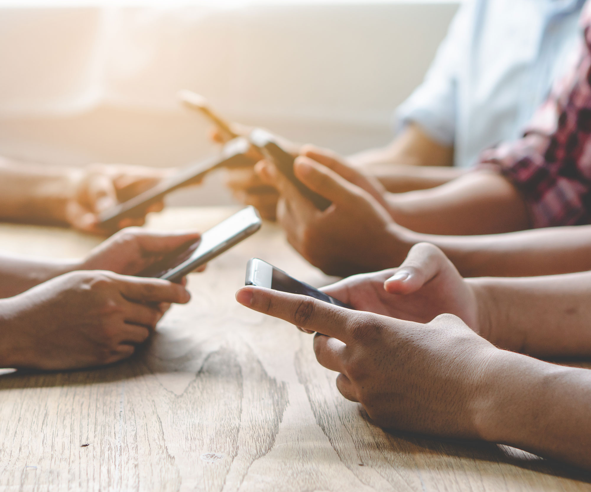 many hands holding mobile phones